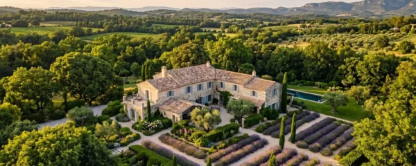 Vue extérieure d'un mas provençal en pierre avec jardin arboré et allée fleurie pour un mariage civil d'exception